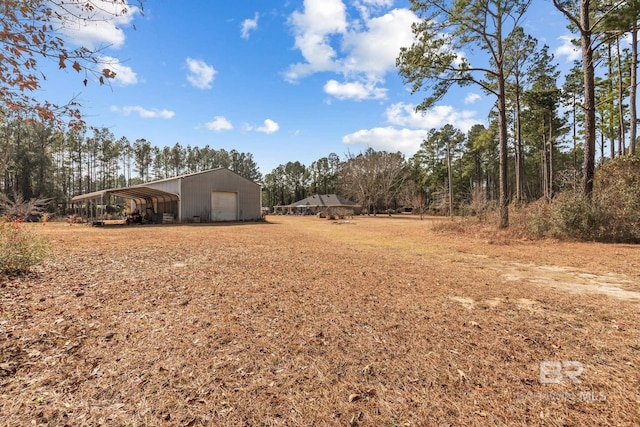 view of yard with an outdoor structure and a carport