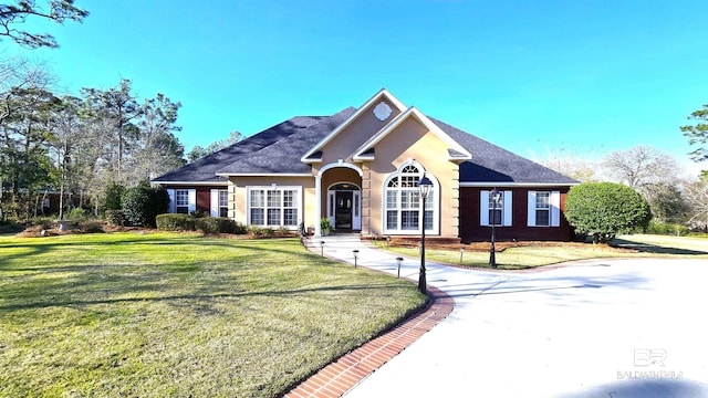 view of front of home featuring stucco siding and a front lawn