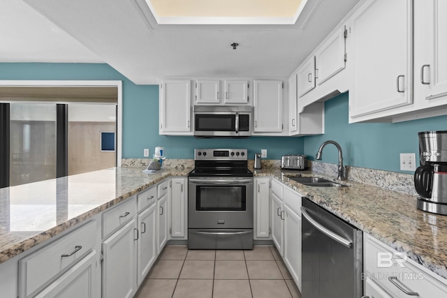 24132 Perdido Beach Blvd Unit 1081, Orange Beach, AL 36561 - kitchen featuring appliances with stainless steel finishes, white cabinetry, light tile patterned floors, and light stone counters