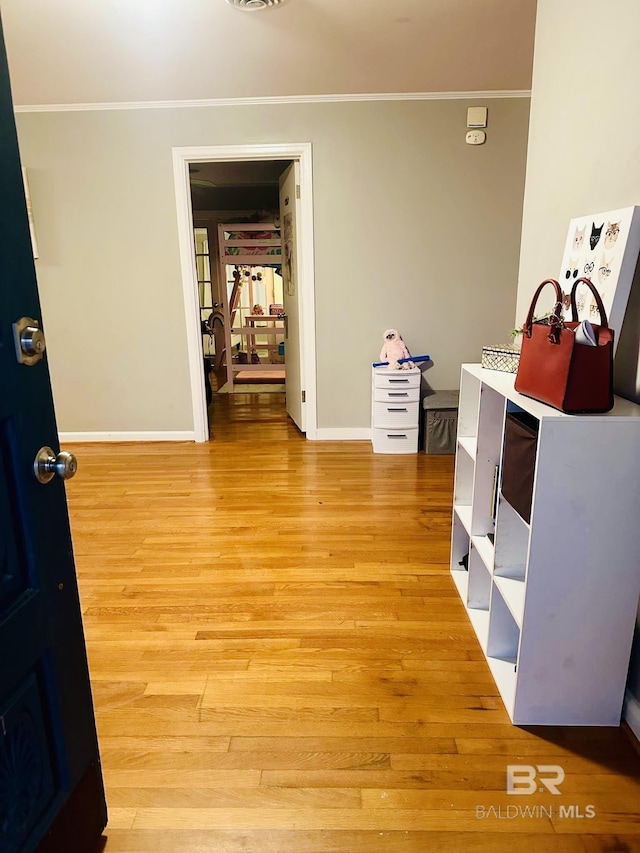 interior space with crown molding and light hardwood / wood-style floors