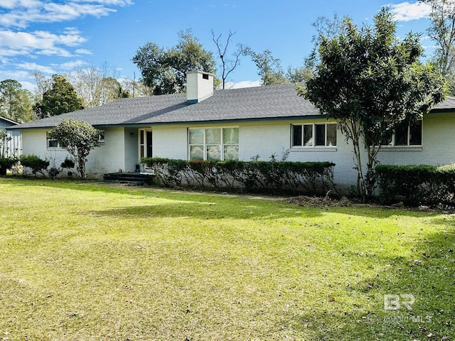 rear view of house featuring a yard