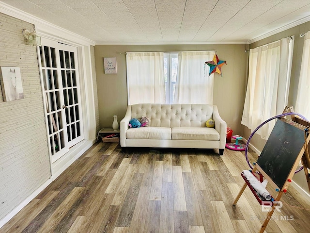 sitting room with hardwood / wood-style floors and crown molding