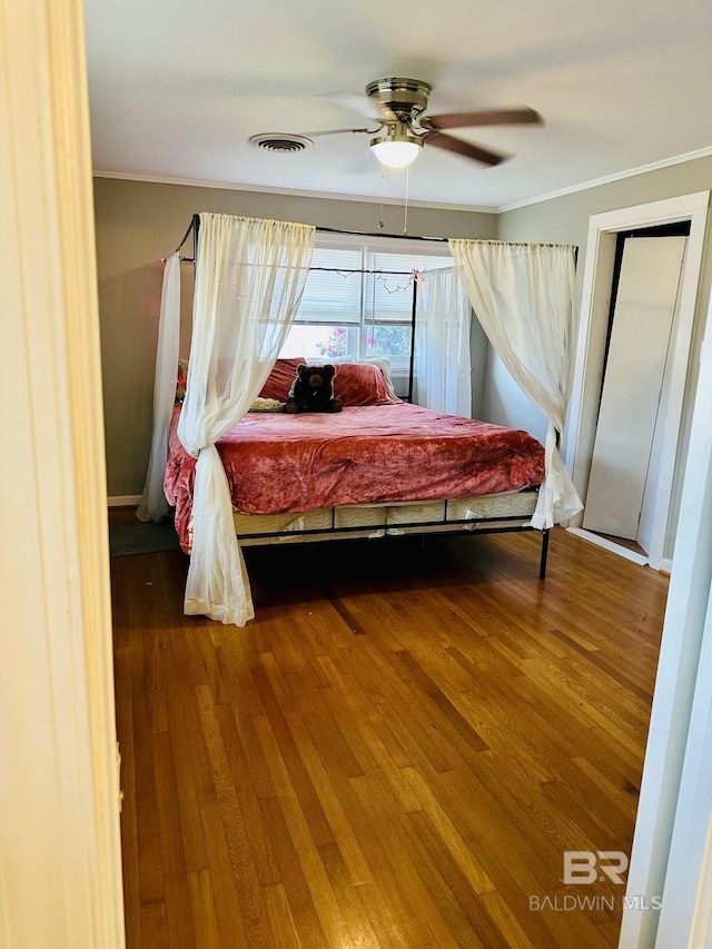 bedroom featuring ceiling fan, hardwood / wood-style flooring, and ornamental molding