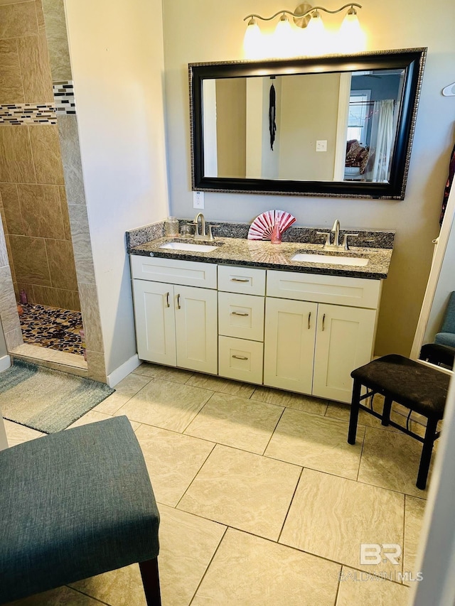 bathroom featuring tile patterned floors, vanity, and a tile shower