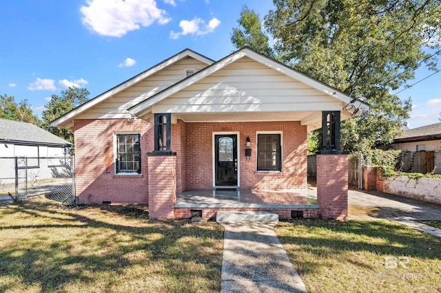 bungalow-style home with covered porch and a front yard