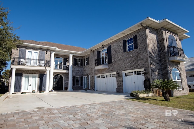 view of front of property featuring a balcony and a garage