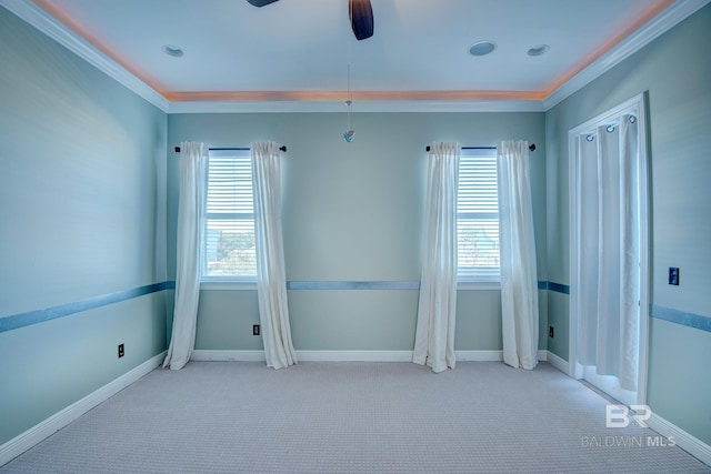 unfurnished room featuring ceiling fan, a healthy amount of sunlight, crown molding, and light carpet