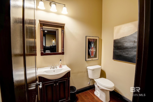 bathroom with hardwood / wood-style floors, vanity, and toilet