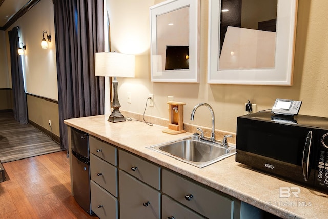 kitchen featuring gray cabinets, light hardwood / wood-style floors, and sink