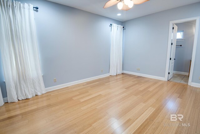 spare room with light wood-type flooring and ceiling fan