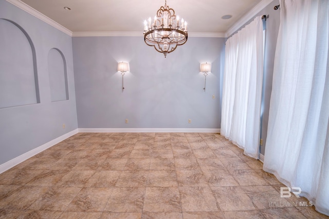 spare room with crown molding and a chandelier