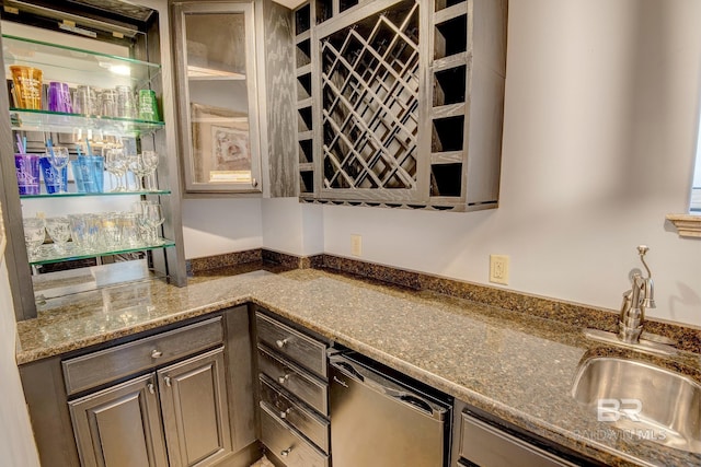 kitchen featuring dishwasher, sink, and stone counters