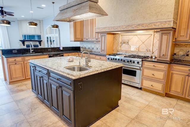 kitchen with premium stove, sink, and dark stone counters