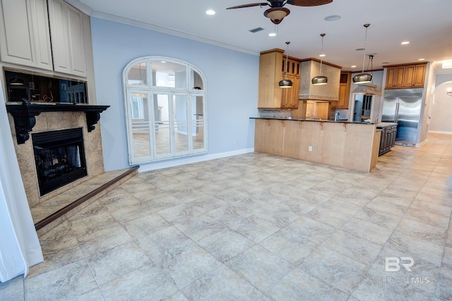 kitchen with pendant lighting, backsplash, crown molding, high end fridge, and kitchen peninsula