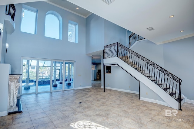 living room featuring a towering ceiling and crown molding