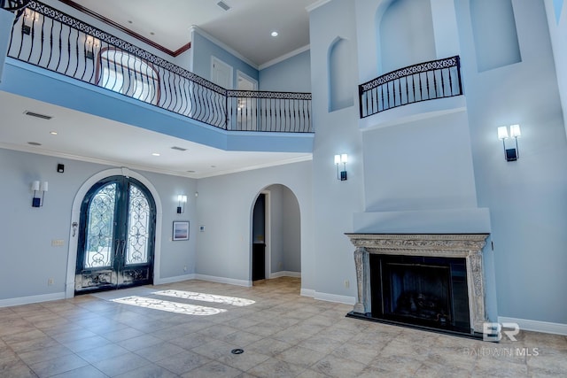 entrance foyer featuring french doors, a towering ceiling, light tile patterned floors, and crown molding