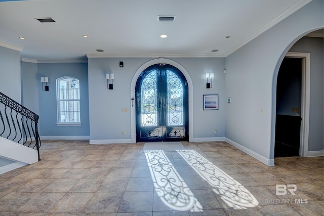 foyer with crown molding and french doors