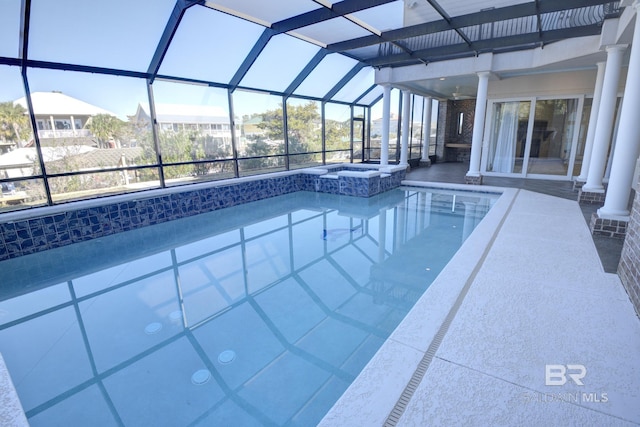 view of pool featuring a lanai and an in ground hot tub