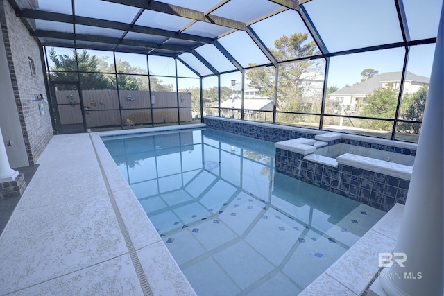 view of pool featuring glass enclosure and an in ground hot tub