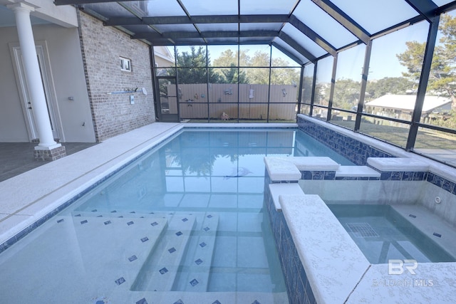 view of swimming pool featuring a lanai and an in ground hot tub