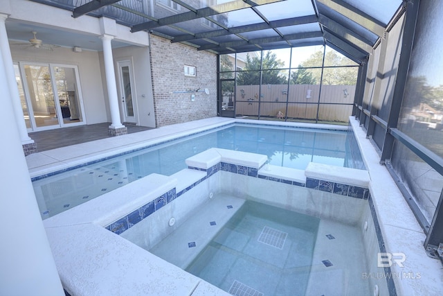 view of swimming pool featuring an in ground hot tub, glass enclosure, and ceiling fan