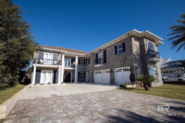 view of front of home featuring a balcony, a garage, and a front lawn