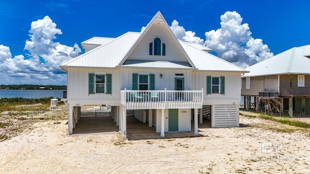 2764 W Beach Blvd, Gulf Shores, AL 36542 - view of front facade featuring board and batten siding, a carport, a metal roof, stairway, and a water view