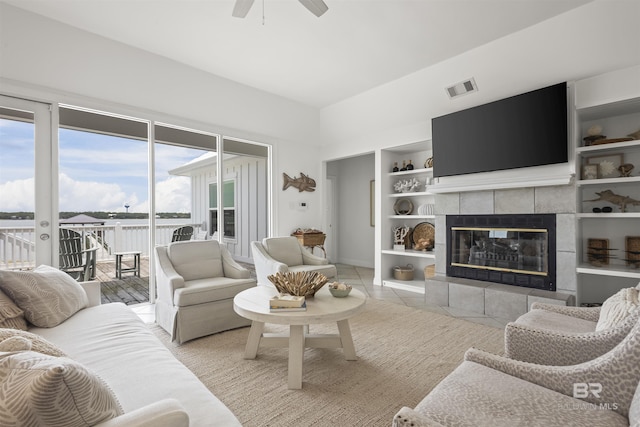 2764 W Beach Blvd, Gulf Shores, AL 36542 - living room featuring a ceiling fan, a fireplace, built in features, and tile patterned floors