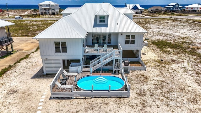 2764 W Beach Blvd, Gulf Shores, AL 36542 - back of house with an outdoor pool, stairway, a metal roof, a water view, and board and batten siding