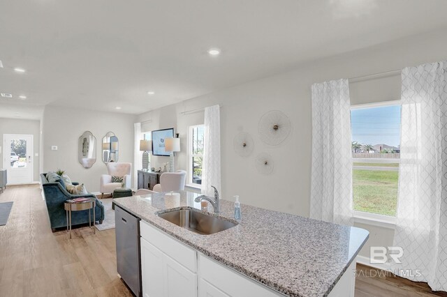 kitchen featuring white cabinets, light hardwood / wood-style floors, dishwasher, and sink