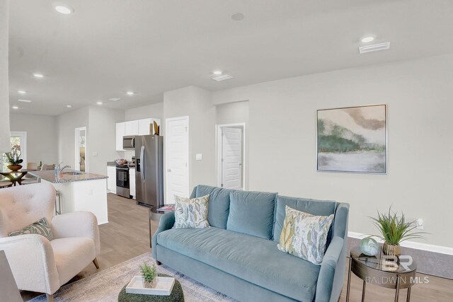 living room with sink and light hardwood / wood-style flooring