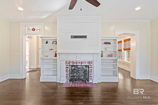 living room with a fireplace, ceiling fan, crown molding, and dark wood-type flooring