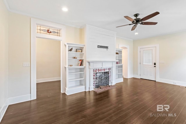 unfurnished living room featuring ornamental molding, a brick fireplace, ceiling fan, and dark wood-type flooring