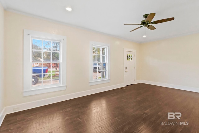 empty room with dark hardwood / wood-style floors, ceiling fan, and ornamental molding