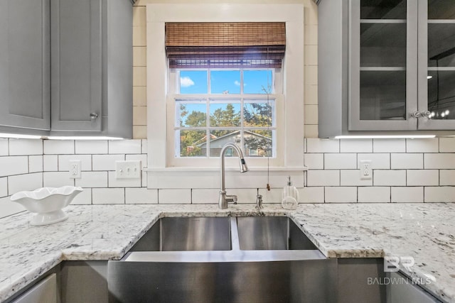 kitchen featuring gray cabinetry, decorative backsplash, and sink