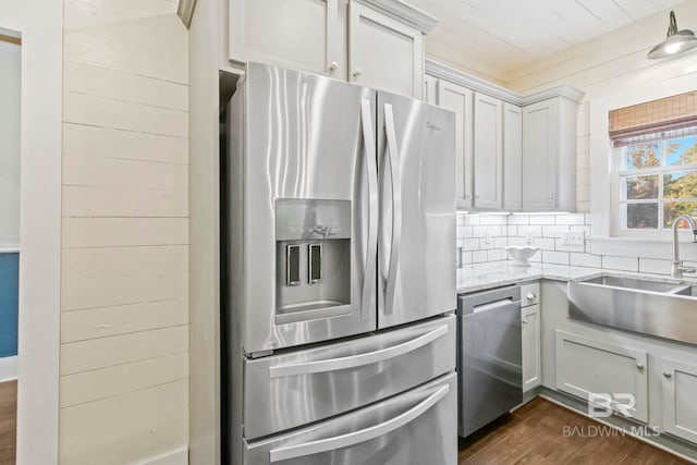 kitchen featuring light stone countertops, sink, dark hardwood / wood-style floors, decorative backsplash, and appliances with stainless steel finishes