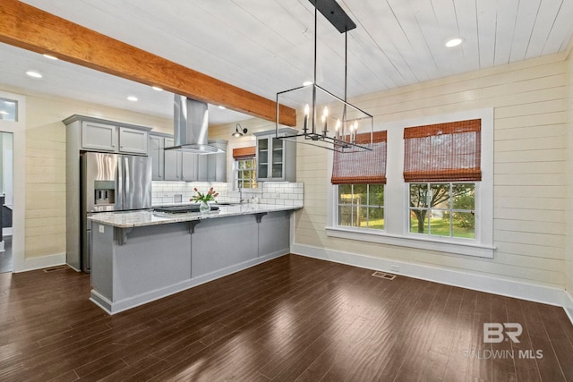 kitchen with kitchen peninsula, dark hardwood / wood-style flooring, tasteful backsplash, ventilation hood, and decorative light fixtures