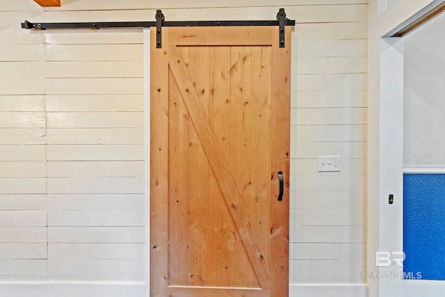 details featuring a barn door and wooden walls