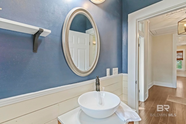 bathroom featuring hardwood / wood-style floors, a notable chandelier, and sink