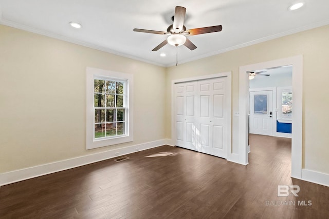 unfurnished bedroom with a closet, ceiling fan, dark hardwood / wood-style flooring, and ornamental molding