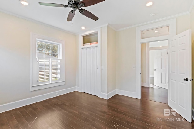 unfurnished bedroom with crown molding, ceiling fan, a closet, and dark wood-type flooring