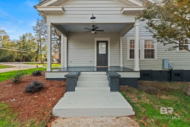 view of exterior entry with ceiling fan and a porch