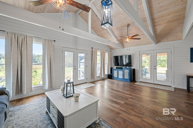 living room with dark hardwood / wood-style flooring, wood walls, and french doors