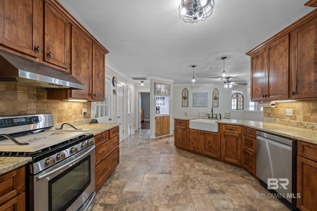 kitchen with sink, kitchen peninsula, decorative light fixtures, appliances with stainless steel finishes, and ornamental molding