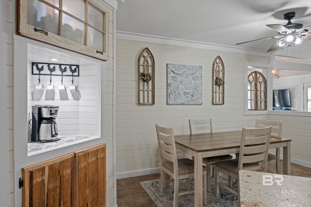 dining room with crown molding, ceiling fan, and wood walls