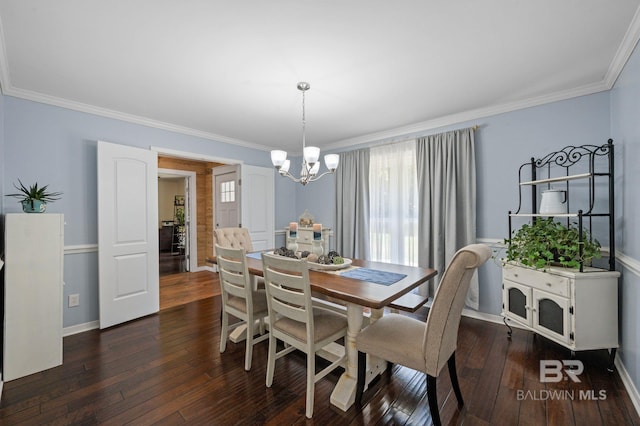 dining space with dark hardwood / wood-style flooring, an inviting chandelier, and crown molding