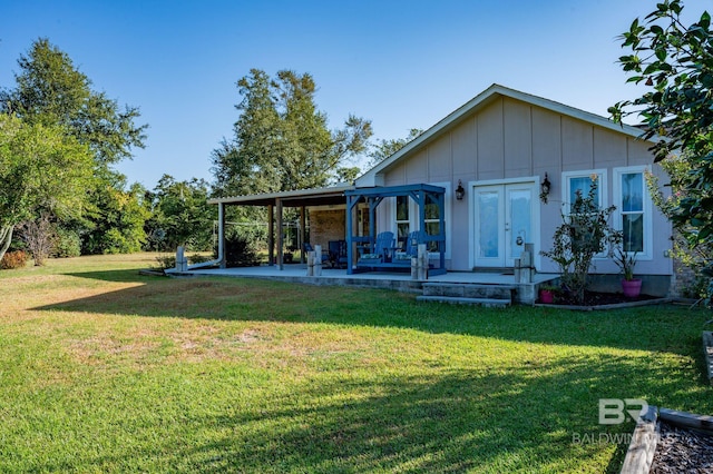 rear view of property featuring a lawn and a patio area