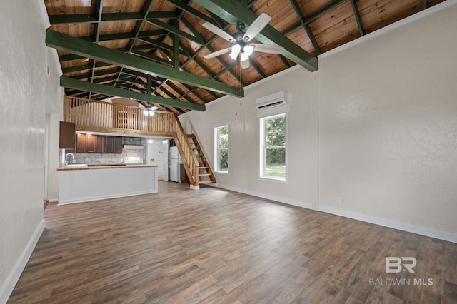 unfurnished living room with a wall unit AC, dark wood-type flooring, high vaulted ceiling, wooden ceiling, and beamed ceiling