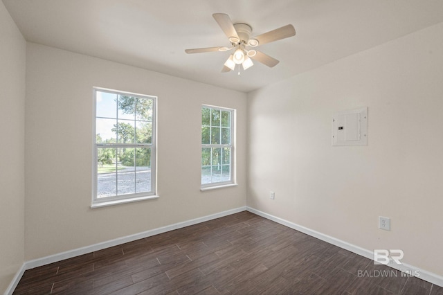 empty room with ceiling fan, dark hardwood / wood-style flooring, and electric panel