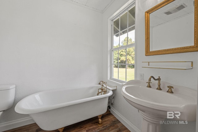 bathroom featuring hardwood / wood-style flooring, toilet, and a bathtub